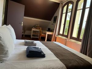 a bedroom with a bed with two towels on it at LA CHERIELLE in Auvers-sur-Oise