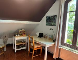 a desk and chair in a room with a window at LA CHERIELLE in Auvers-sur-Oise