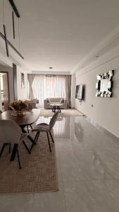 ein Wohnzimmer mit einem Tisch und einem Sofa in der Unterkunft Bloomstays Furnished Apartments Nairobi - Two Bedroom With Sauna Gym & Workspace in Nairobi