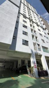 ein großes weißes Gebäude mit einem davor geparkten Auto. in der Unterkunft Bloomstays Furnished Apartments Nairobi - Two Bedroom With Sauna Gym & Workspace in Nairobi