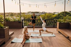 a group of women doing yoga on a rooftop deck at Awwa Boutique Hotel in Canggu +59 photos