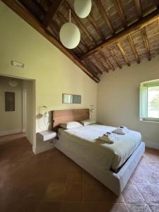 a bedroom with a large bed and a wooden ceiling at Podere Le Marene in Scoppieto