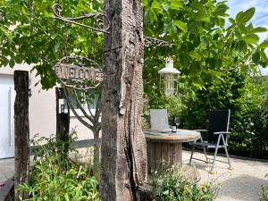 a tree with a table and a sign in a garden at Gemütliches Eifeler Gästehäuschen in Nettersheim