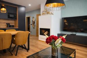 a living room with a vase of flowers on a glass table at Apartmán Alica Tále in Bystrá