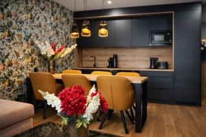a kitchen with a table with chairs and flowers at Apartmán Alica Tále in Bystrá