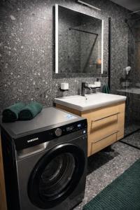 a bathroom with a washing machine and a sink at Apartmán Alica Tále in Bystrá +12 photos