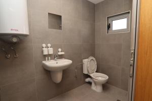 a bathroom with a toilet and a sink at Хотел КО НИ КО in Stara Zagora +37 photos
