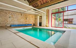 an indoor swimming pool with a brick wall at Les 4 AS de Jaunay, Intime, Jacuzzi in Jaunay-Clan