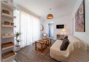 a white living room with a couch and a table at Appartement à la Centrale avec vue Océan in Soorts-Hossegor