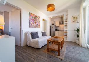 a living room with a white couch and a table at Appartement à la Centrale avec vue Océan in Soorts-Hossegor