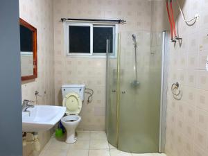 a bathroom with a toilet and a sink and a shower at Belle view Villa in Serekunda