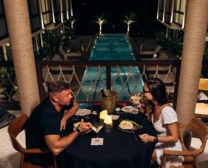a group of people sitting at a table eating food at Awwa Boutique Hotel in Canggu
