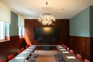 a conference room with a long table and a television at Hotel Daniel Graz - Smart Lifestyle Near City Centre in Graz