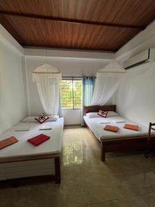 a bedroom with two beds and a window at Bungalow Resort - Sigiriya in Sigiriya +78 photos