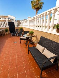 a patio with chairs and a table on a balcony at Almohabenos Pool View in Punta Prima