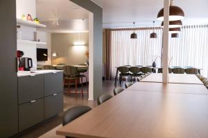 a kitchen and dining room with a long table and chairs at Het Kasterhuis - Gastenverblijf in Wetteren