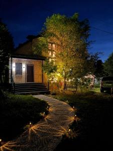 a walkway leading to a house at night with lights at Burabay Lake Walk House in Borovoye