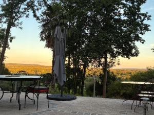 a patio with tables and chairs and an umbrella at LA CHERIELLE in Auvers-sur-Oise +13 photos