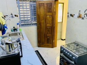 a kitchen with a stove and a sink at Kër-Mame Tawfekh in Thiès
