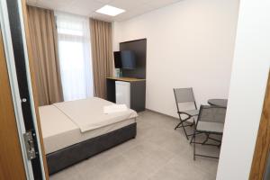a bedroom with a bed and a table and chairs at Хотел КО НИ КО in Stara Zagora