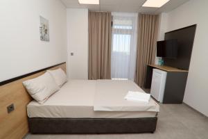 a hotel room with a bed and a television at Хотел КО НИ КО in Stara Zagora