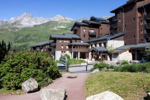 a group of buildings with mountains in the background at Résidence Odalys Le Hameau du Mottaret in Méribel
