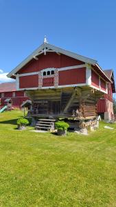 a large red barn with a green field in front of it at Suigard Veslestugo in Sauland