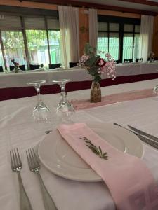 a table with a white plate with a pink napkin at Hotel Entrelagos in Ruidera