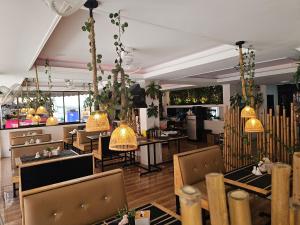a restaurant with tables and chairs and pendant lights at Candy Beach Seaview Jomtien in Jomtien Beach