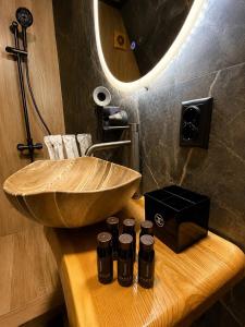 a bathroom with a wooden bowl sink and five bottles at AFRAME Solotvino in Solotvyno +47 photos