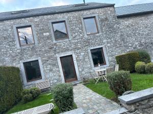 a stone building with a bench in front of it at Private room with shared bathroom in Clavier +3 photos