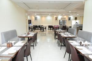a dining room with wooden tables and chairs at Hotel Siya Grand in Tirupati