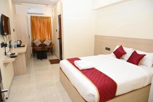 a bedroom with a large bed with red pillows at Hotel Siya Grand in Tirupati