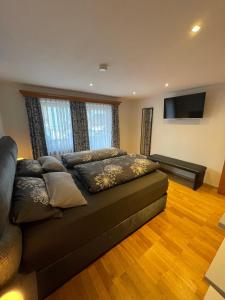 a bedroom with a couch and a flat screen tv at Schuhhaus Biberger - Fewo Lukas in Schönau am Königssee