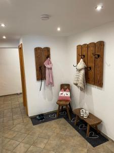a room with a wall with wooden hangers and shoes at Schuhhaus Biberger - Fewo Lukas in Schönau am Königssee