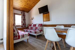 a living room with a table and chairs at Résidence Odalys Le Hameau du Mottaret in Méribel