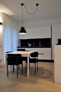 a kitchen with a white table and black chairs at Junior Suite agli Archetti in Torri del Benaco