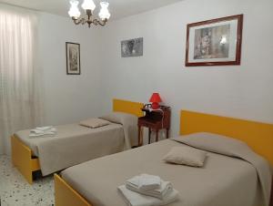 a room with two beds and a table and a mirror at Casa Relax in Carunchio