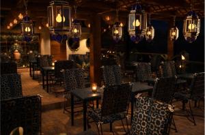 a dining room with tables and chairs and chandeliers at Auberge Resto Agnaoue in Marrakesh