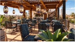 a restaurant with blue chairs and tables on a balcony at Auberge Resto Agnaoue in Marrakesh