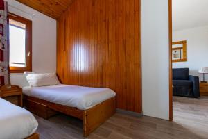 a bedroom with two beds and a chair in a room at Résidence Odalys Le Hameau du Mottaret in Méribel +48 photos