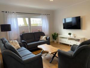 a living room with couches and a flat screen tv at Ferienwohnungen in Böhme in Böhme