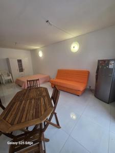 a room with a couch and a table and a refrigerator at Studio ALIZÉS in Le Moule