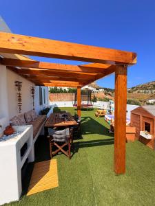 a patio with a wooden pergola on the grass at Apademia Comfort Studio 65sqm in Skiros