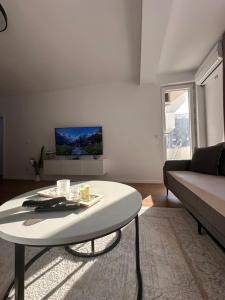 a living room with a coffee table and a couch at Bright flat in Fushë Kosova in Kosovo Polje