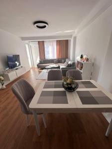 a living room with a table and a couch at Bright flat in Fushë Kosova in Kosovo Polje +12 photos
