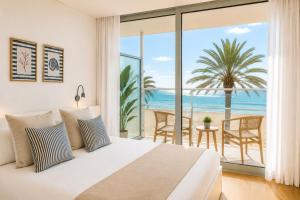 a bedroom with a bed and a view of the ocean at Meraki Beach Hotel - Only Adults in Playa Pobla de Farnals
