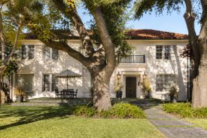 a white house with a tree in front of it at Spacious Loft Condo w Pool & Fireplace in Dallas