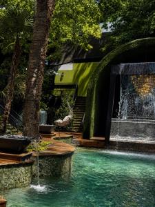 a swimming pool with a fountain in a yard at Spacious Loft Condo w Pool & Fireplace in Dallas