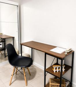 a desk with a black chair and a table at Charmoso apartamento na Lapa in Rio de Janeiro +9 photos
